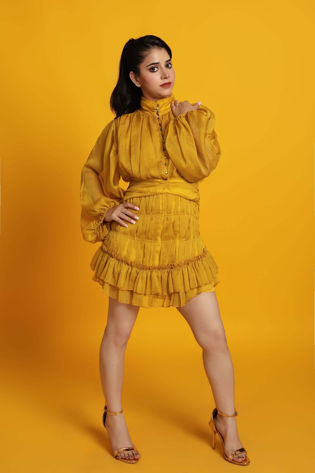 Neeru Sharma in a mustard dress, seated