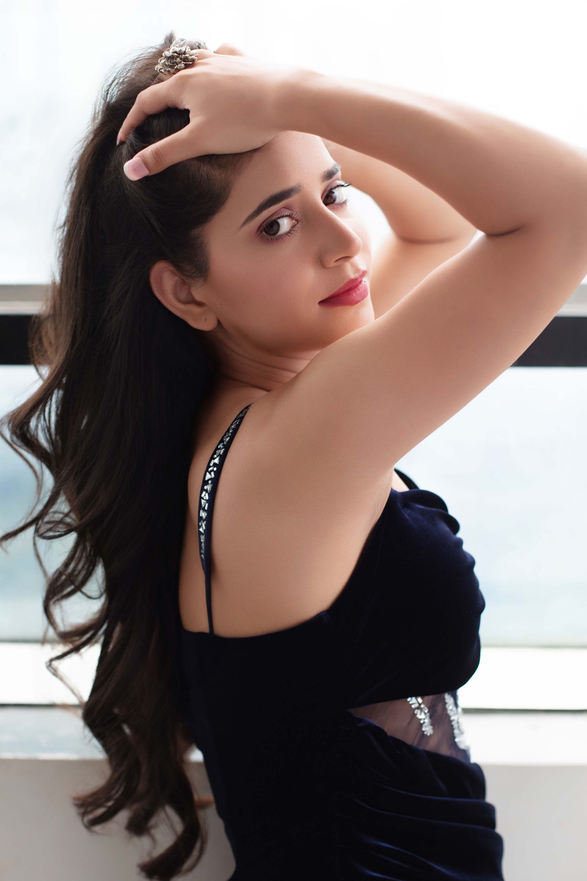 Neeru Sharma in a navy velvet gown, looking back over her shoulder
